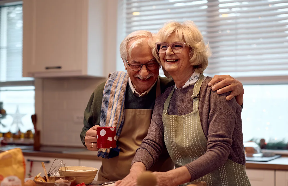 an elderly couple baking in their kitchen